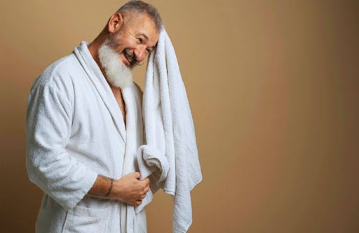 an elderly man drying after receiving the benefits of an infrared (IR) sauna session.