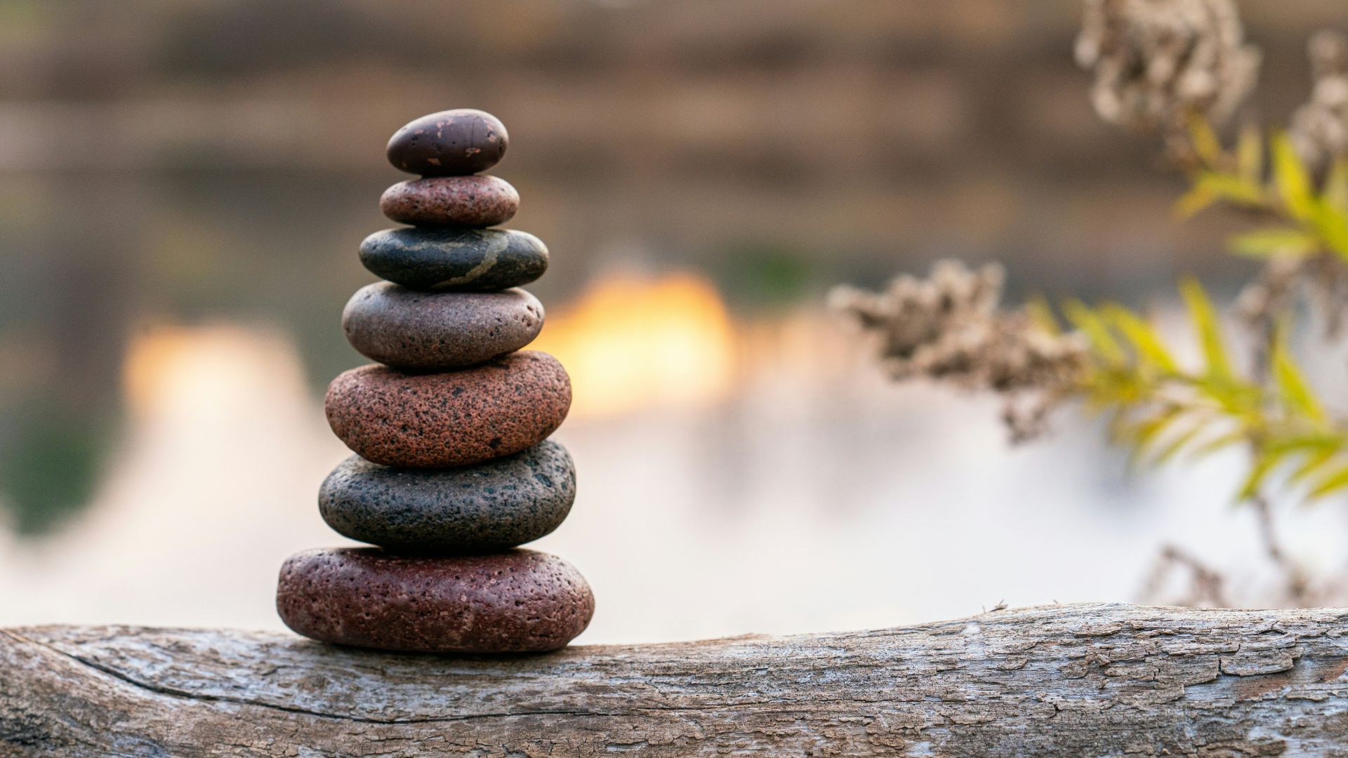 Made with focus, a column of stones stacked for calm near a lake